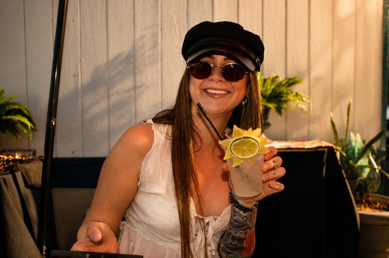 Guest smiling with a garnished cocktail at the bar